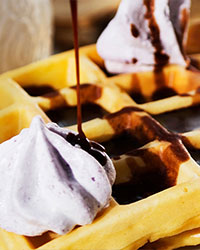 Waffle com calda de chocolate e café